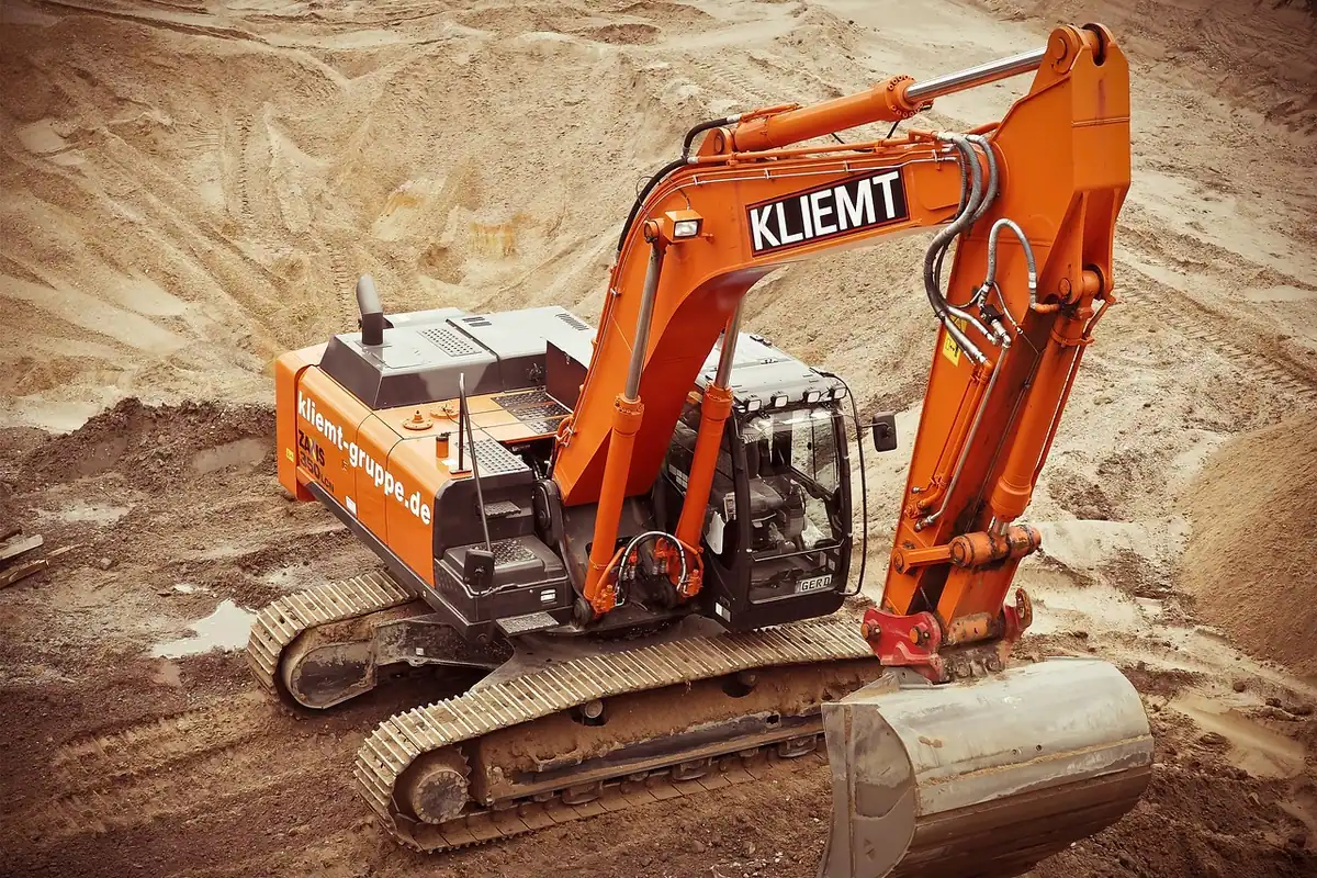 Excavator cu cupă de săpat lucrând pe un șantier de construcții, în timpul unor lucrări de excavare