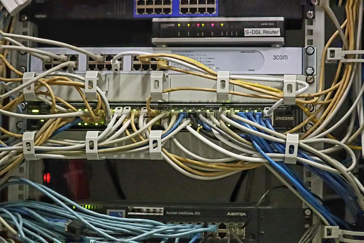 Echipamente de server într-un dulap tehnic, cu cabluri de rețea conectate, într-o încăpere IT