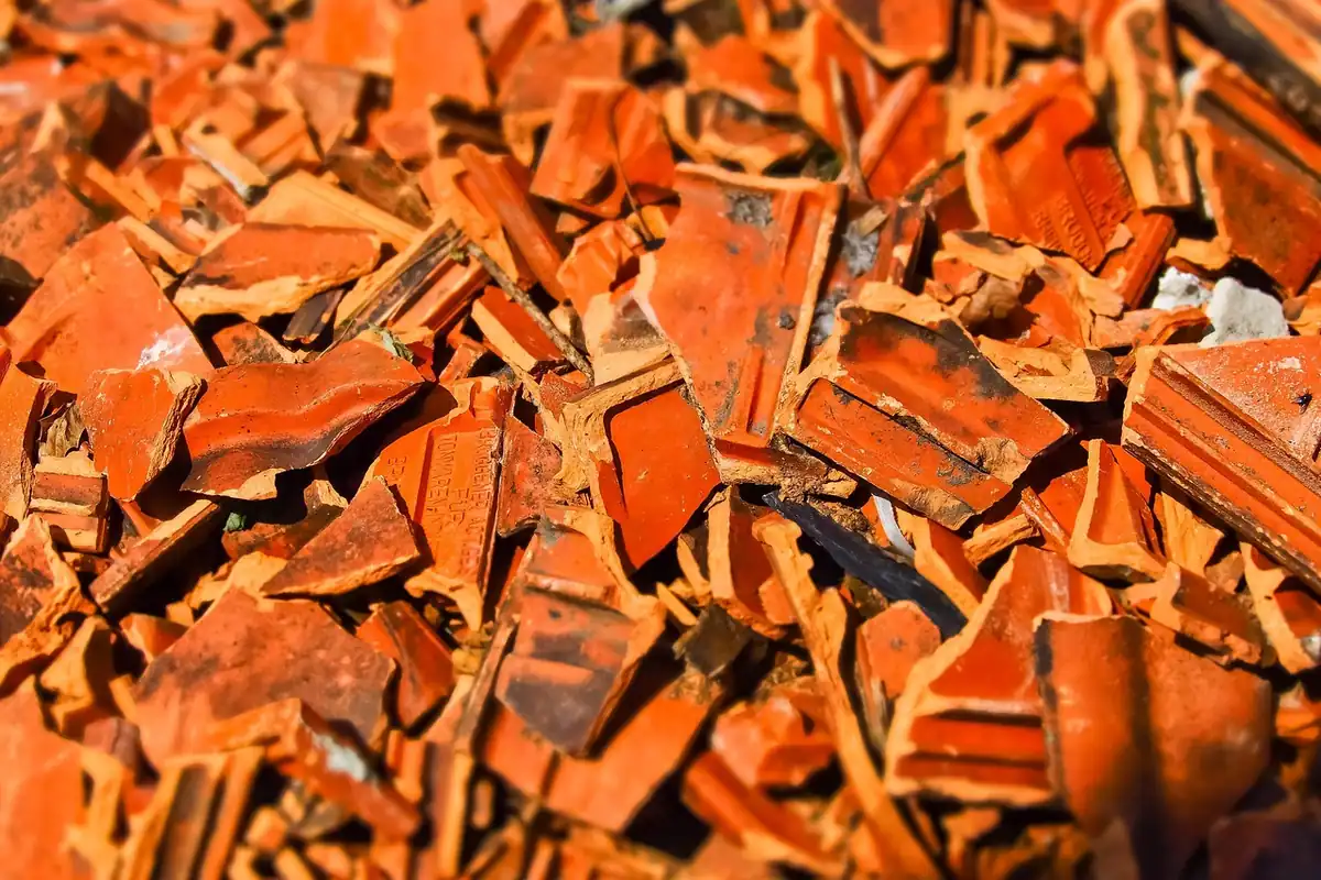Fragmente de țiglă ceramică portocalie sparte, strânse grămadă