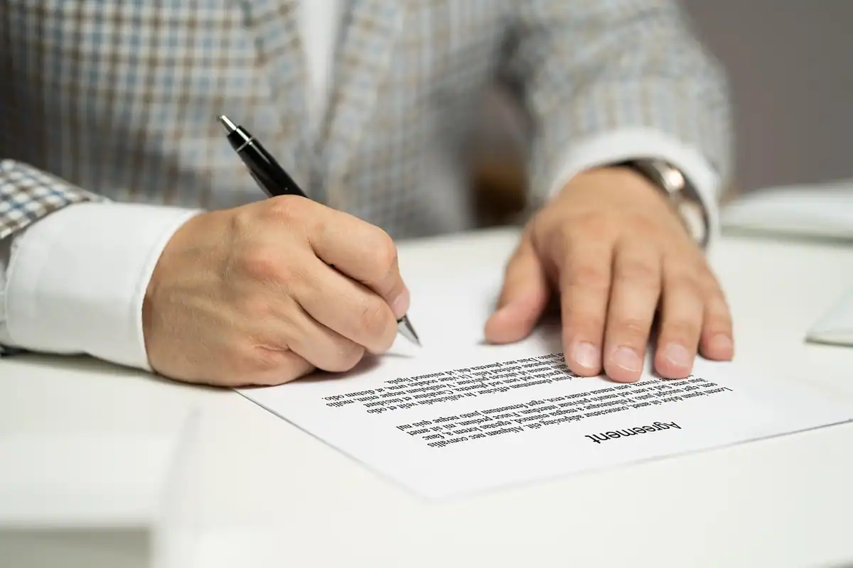 Semnarea unui contract, cu document și semnătură, în cadrul unui acord de afaceri