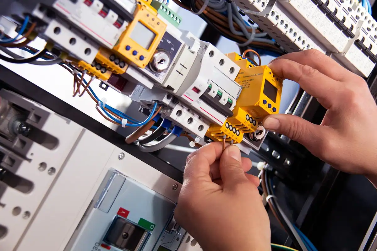 Electrician montează siguranțe automate în tabloul electric al casei
