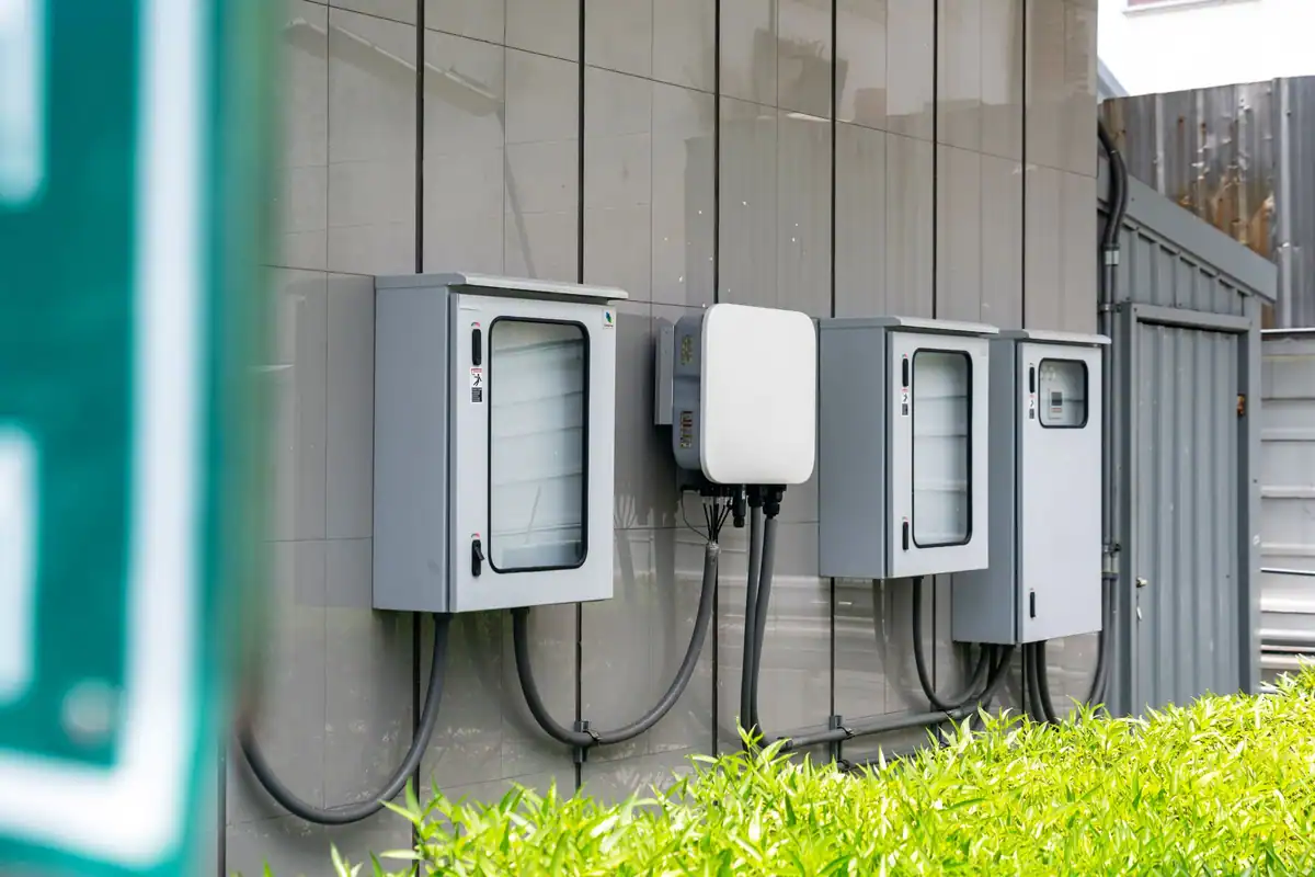 Prim-plan cu doze electrice exterioare și cabluri pe fațada unei clădiri