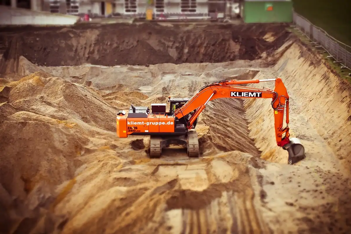 Excavator pe un șantier de construcții, cu cupă, lucrând la o clădire nouă