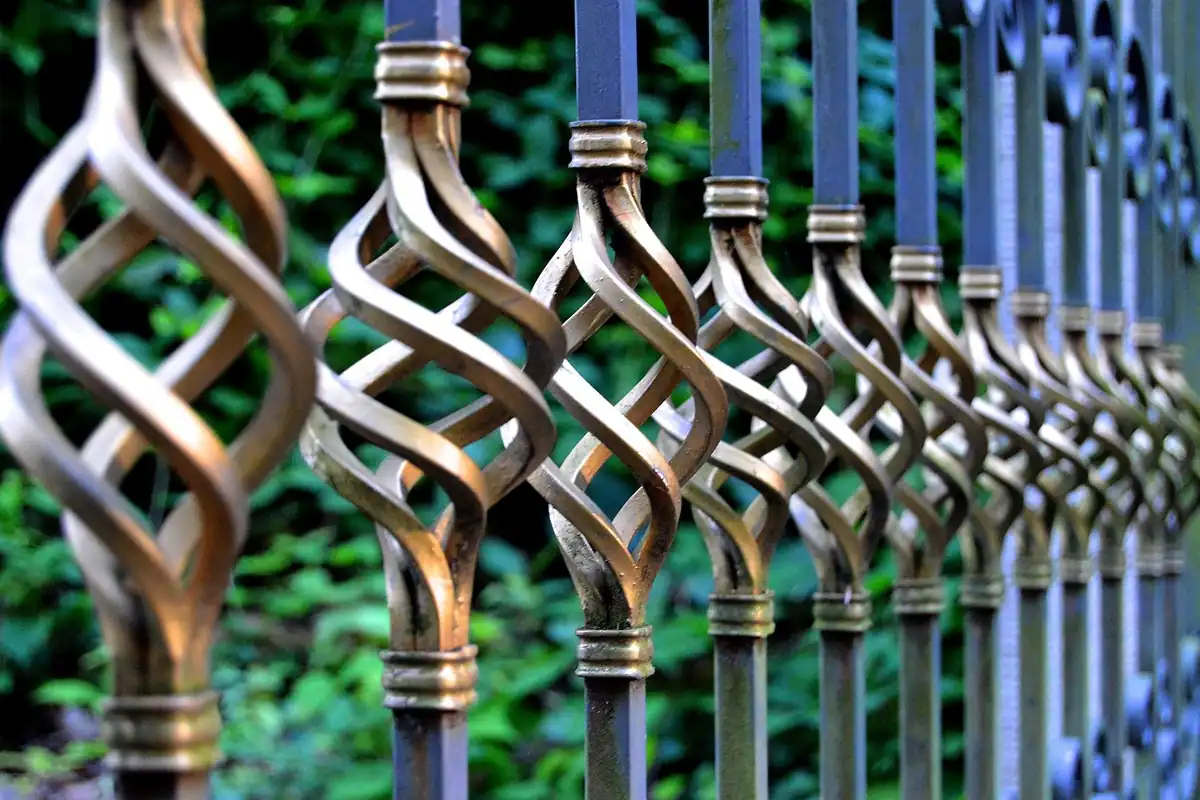 Poartă și gard din fier forjat, cu bare metalice decorative, văzute în perspectivă