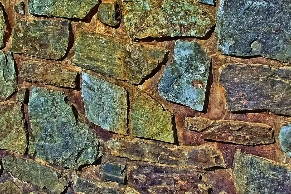 Zid de piatră naturală cu pietre de dimensiuni diferite, cu aspect de zidărie