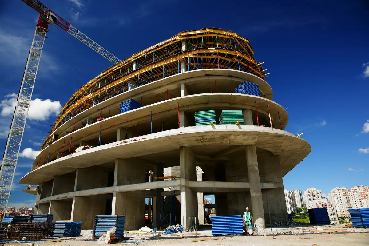 Clădire cu planșee din beton turnate în formă curbă, cu macara alături