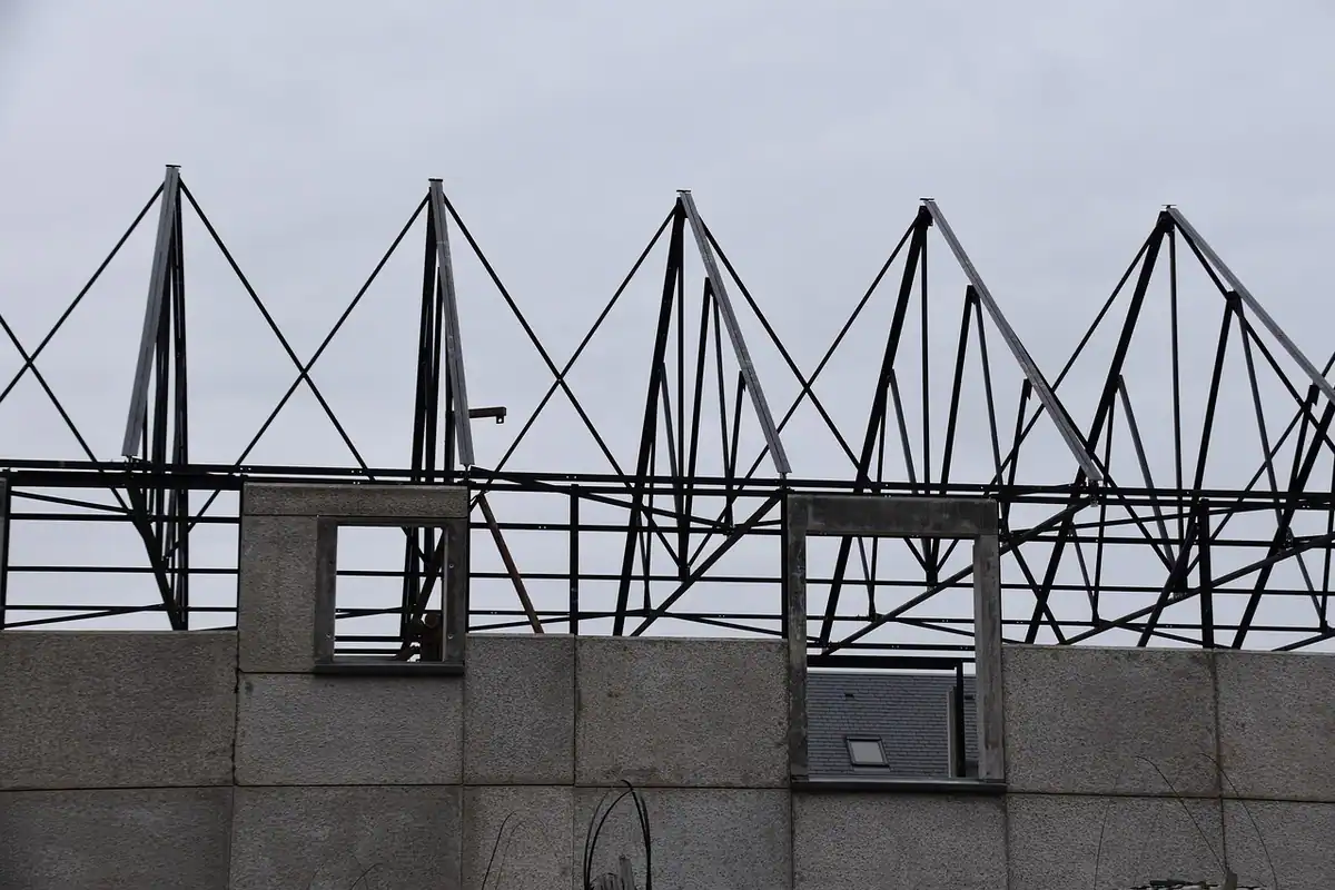Schelet metalic deasupra unui zid de beton cu o fereastră